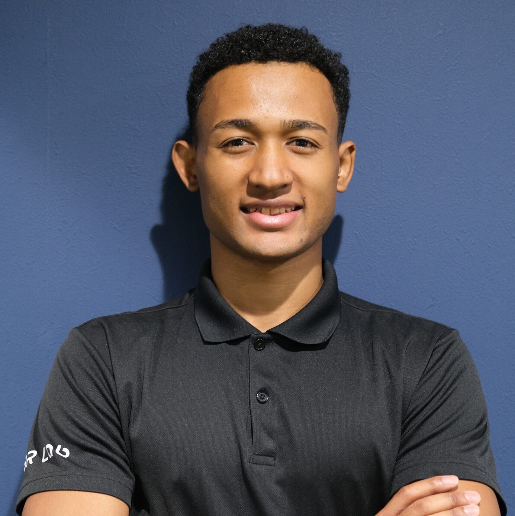 BRLab北浦和店所属のダイエット指導が得意なパーソナルトレーナー森本セエチュルバルです。筋肉質でスタイルが良い、笑顔の男性が腕を組んでいます。